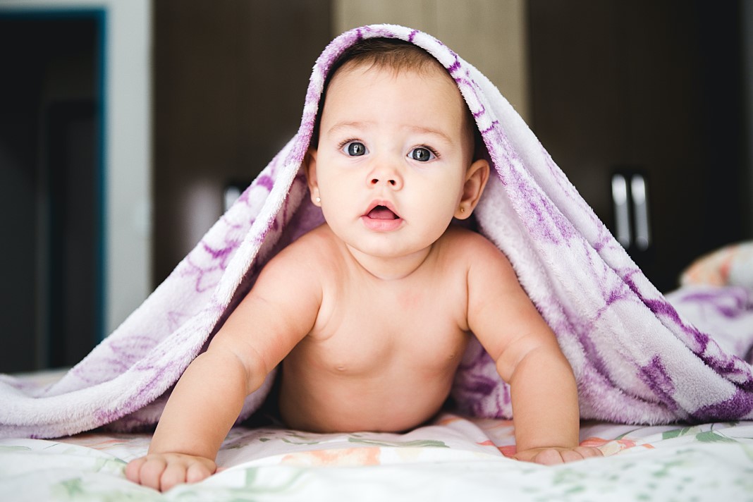 Bebé debajo de una manta morada